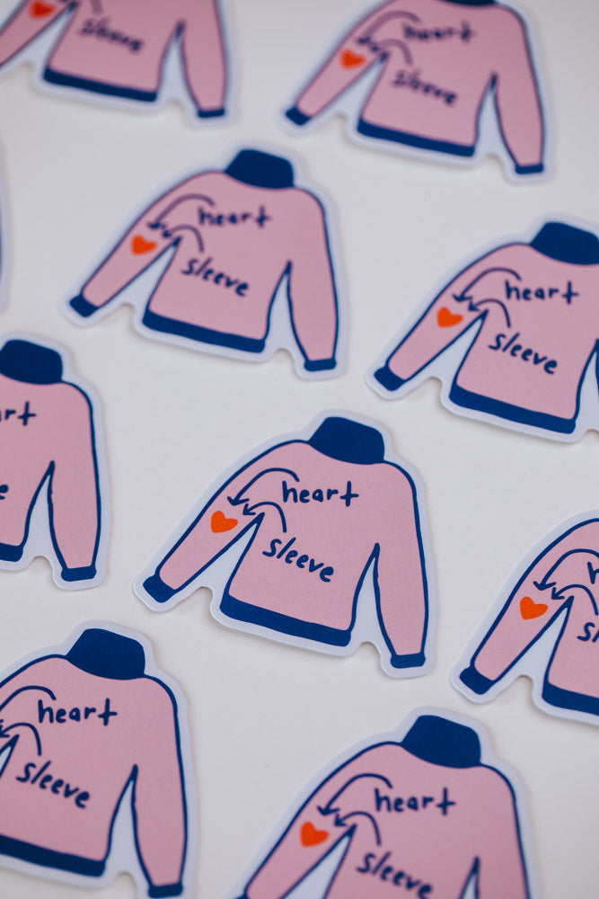 Multiple pink sweater stickers labeled "heart" and "sleeve" with an arrow pointing to a small red heart on the left sleeve.