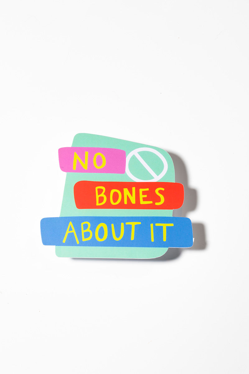 Sticker that reads "No bones about it" in yellow no pink, red, and blue blocks on a teal sticker all shot on a white background.