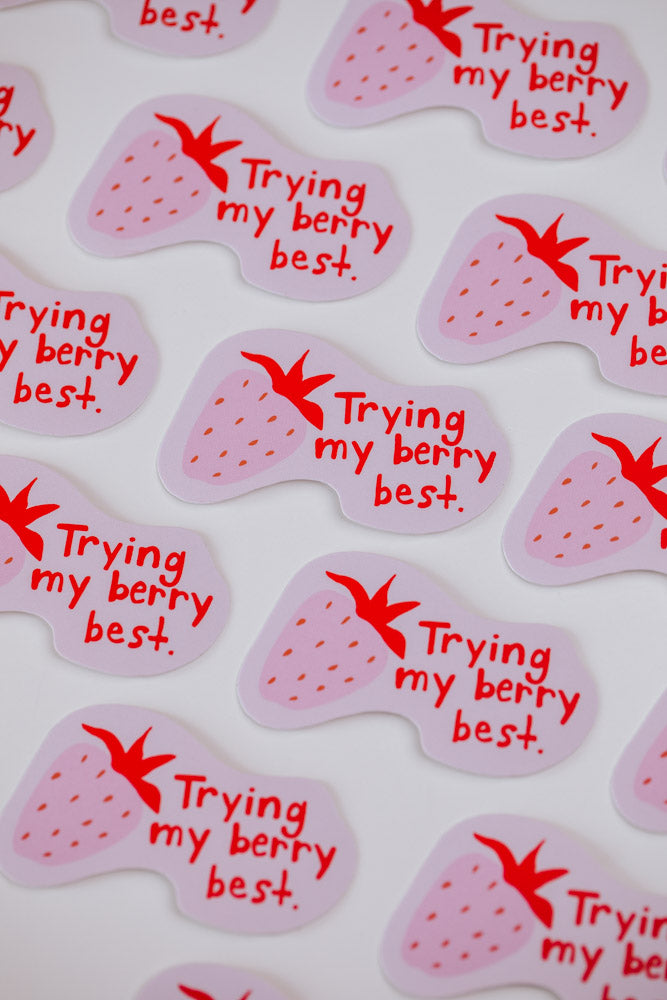Multiple stickers with a pink strawberry illustration and red text reading "Trying my berry best" arranged on a white background.