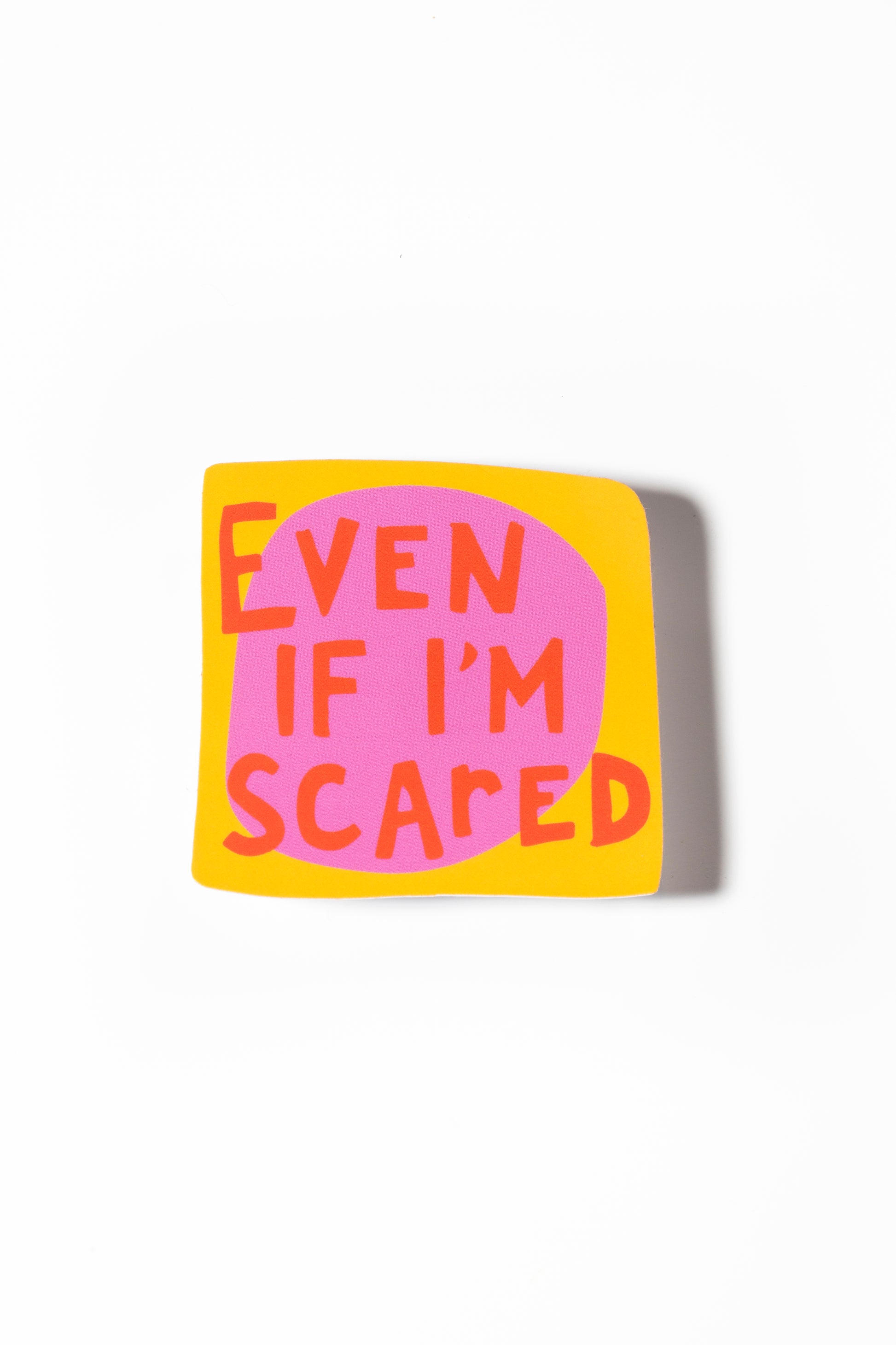 An image showing a single square sticker with the text "Even if I'm scared" written in red letters on an orange background, placed against a plain white background.