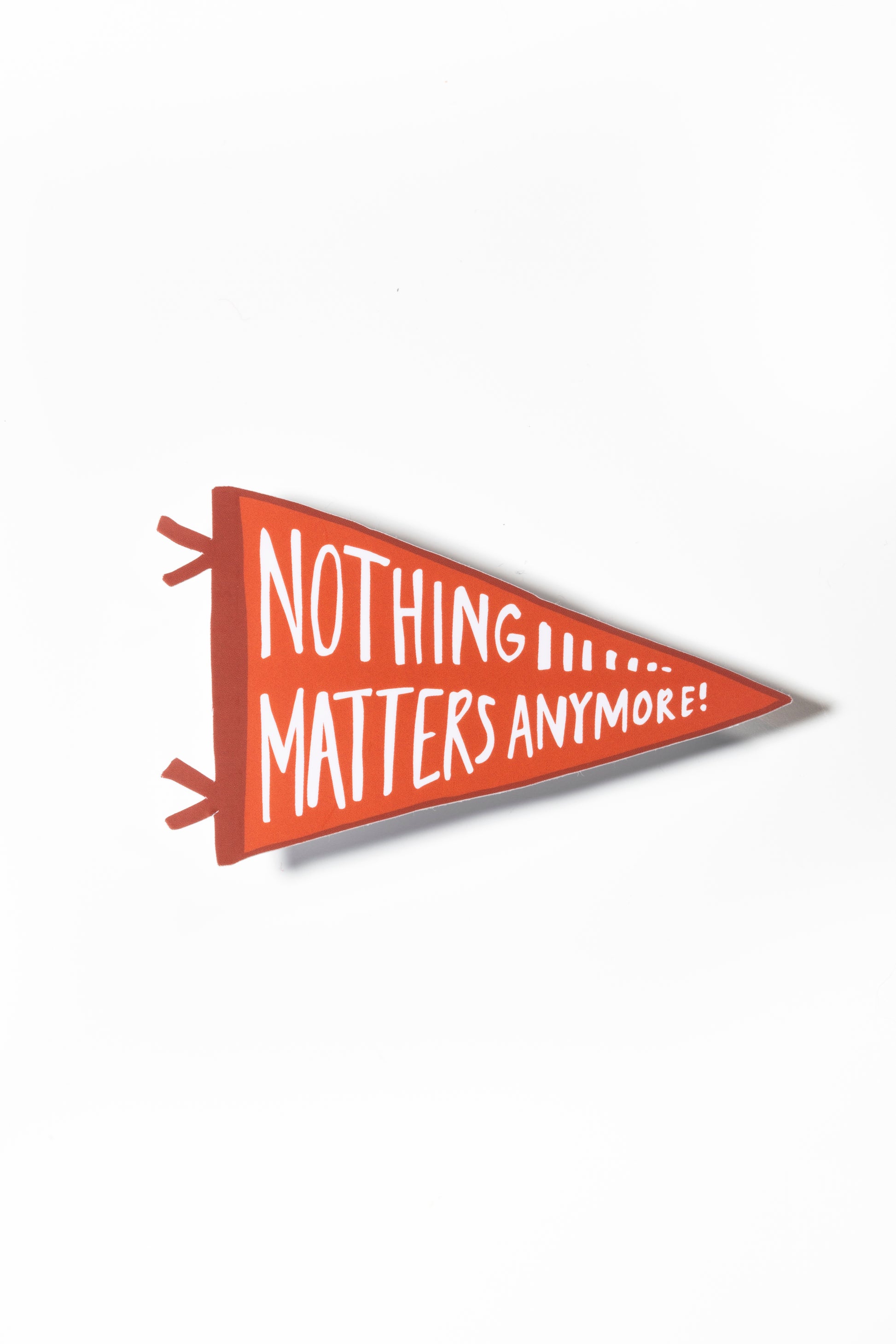 Red pennant sticker that reads "Nothing matters anymore" shot on a white background.